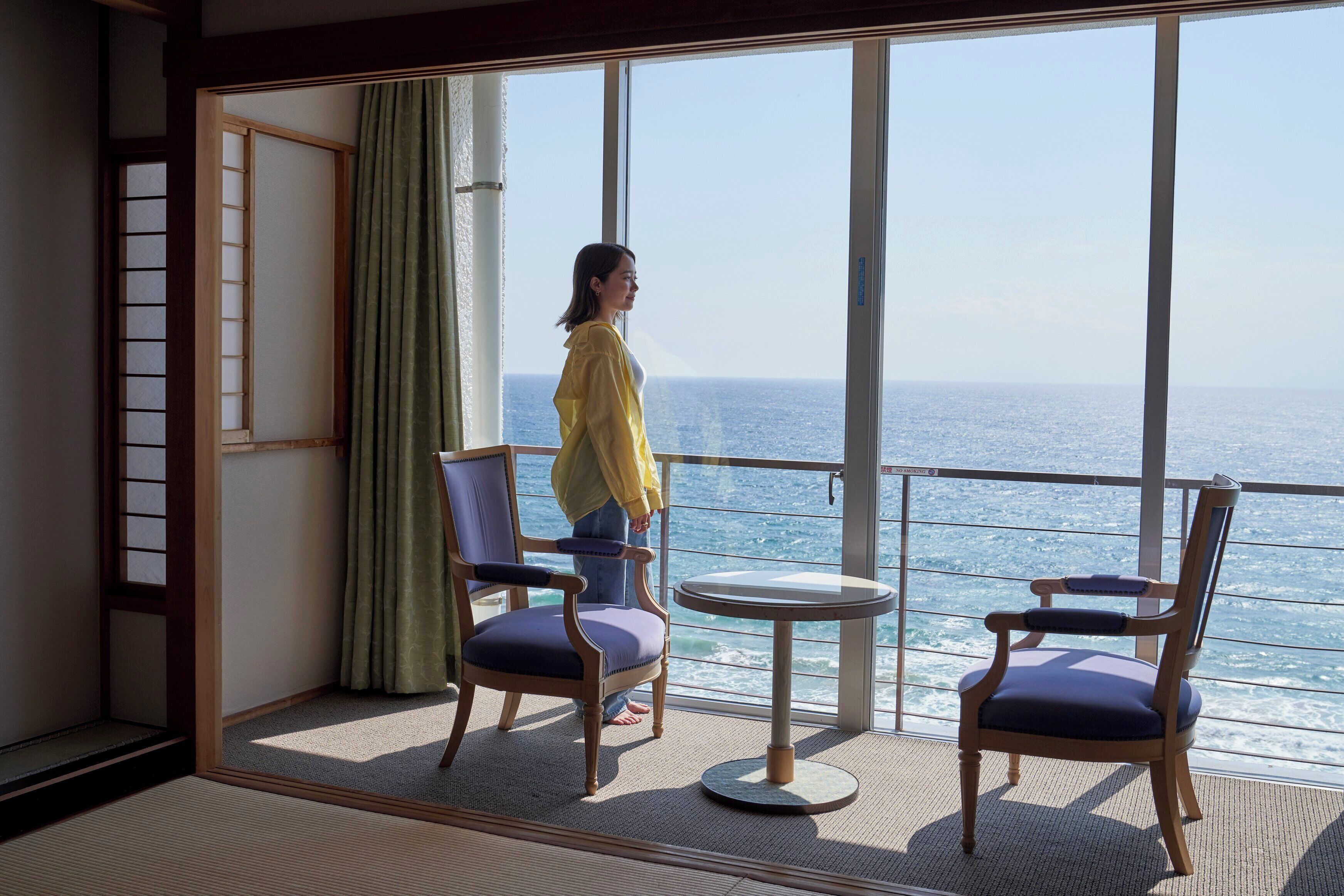 Habitación con vistas al mar, con dos sillas y una mesita.