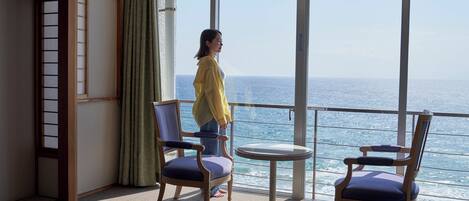 Habitación con vistas al mar, con dos sillas y una mesita.