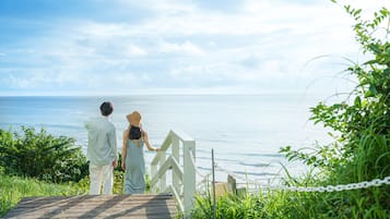 A wooden deck with a white railing overlooking a body of water.