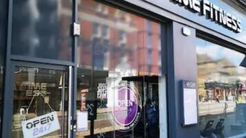 A storefront with a sign that reads "ANYTIME FITNESS".