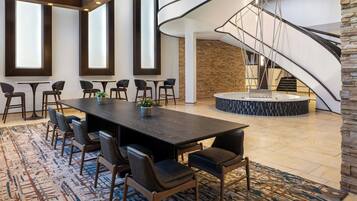 Une salle de conférence moderne, dotée d’une grande table, de chaises et d’un escalier.