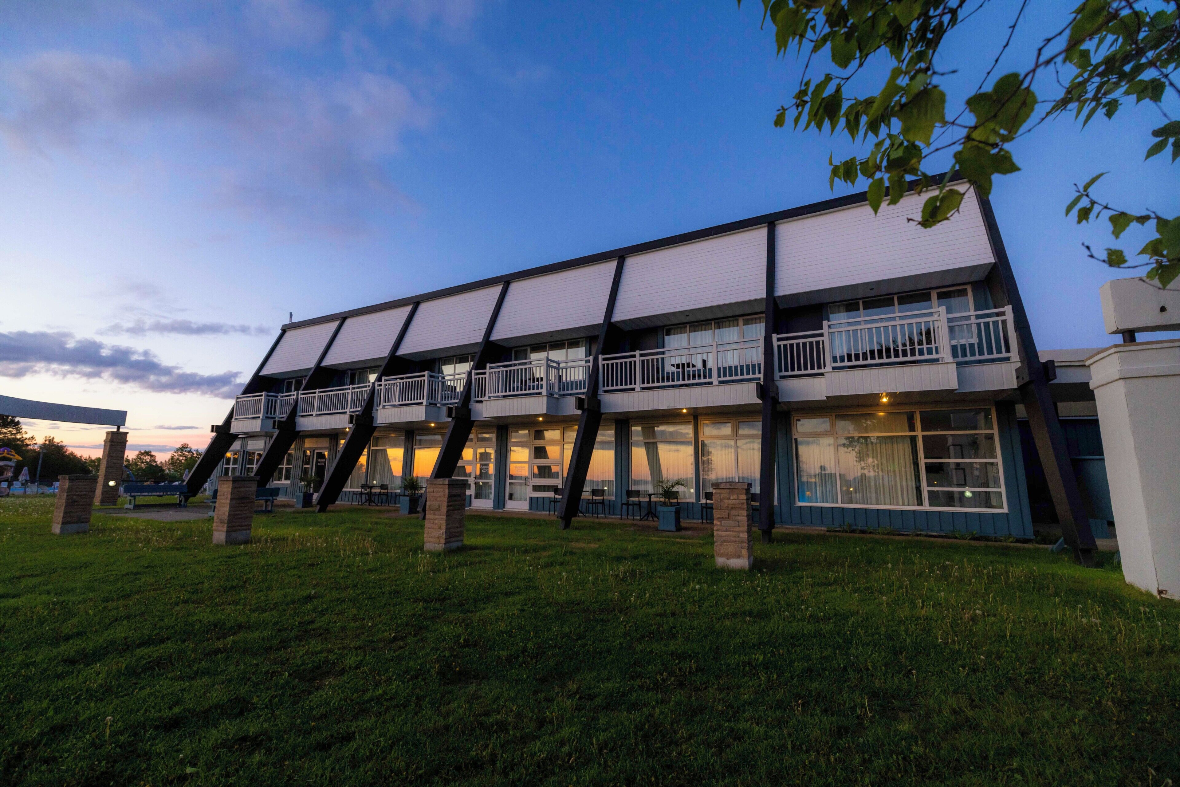 A modern building with a flat roof, large windows, and a balcony.