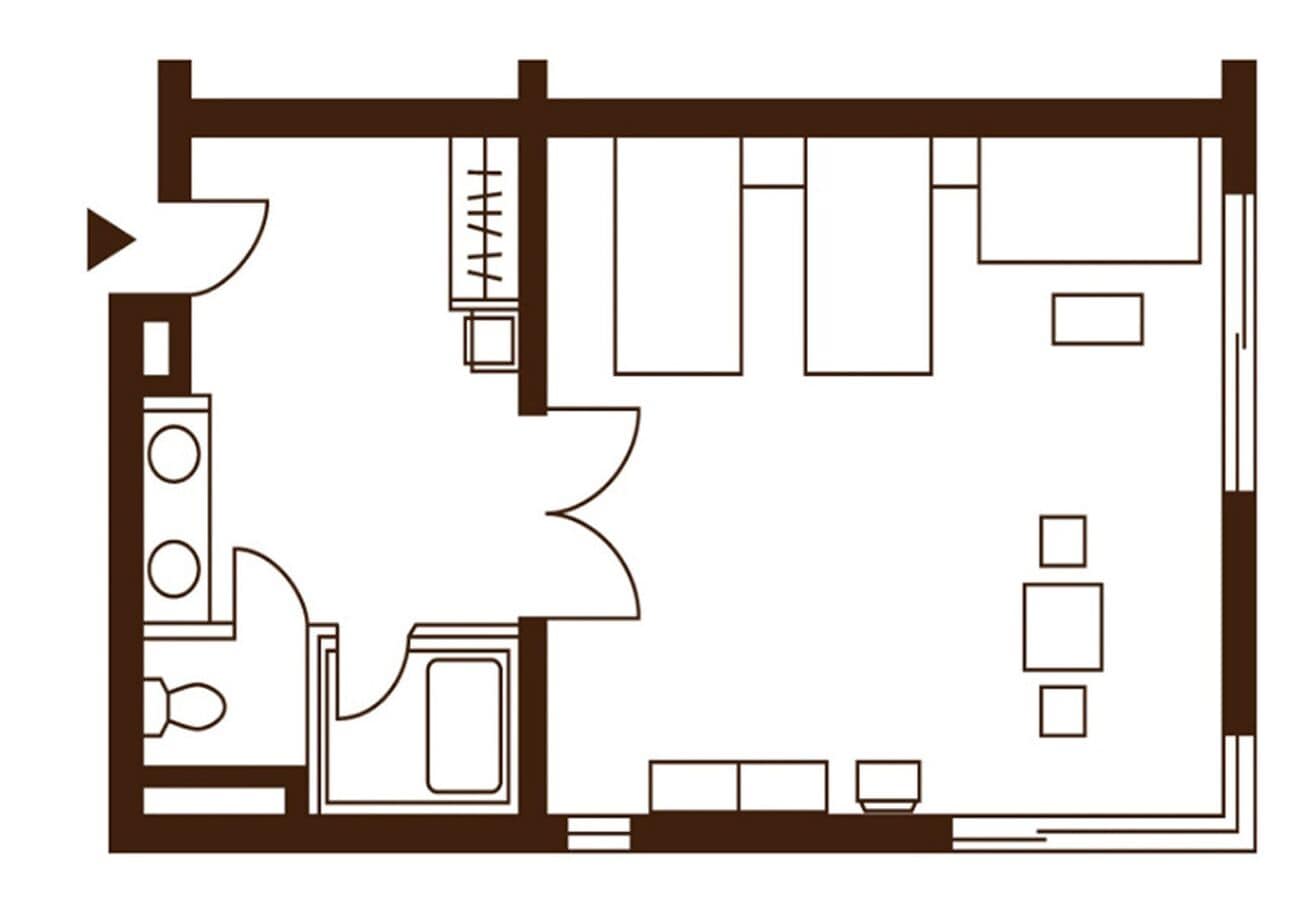 Un plan d’étage d’une chambre d’hôtel comprenant un coin cuisine, un espace salon avec un canapé et des fauteuils, et une petite table.