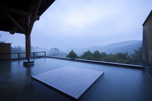 A spacious room with a large window overlooking misty mountains. - Tsumagoi Prince Hotel (Tsumagoi)