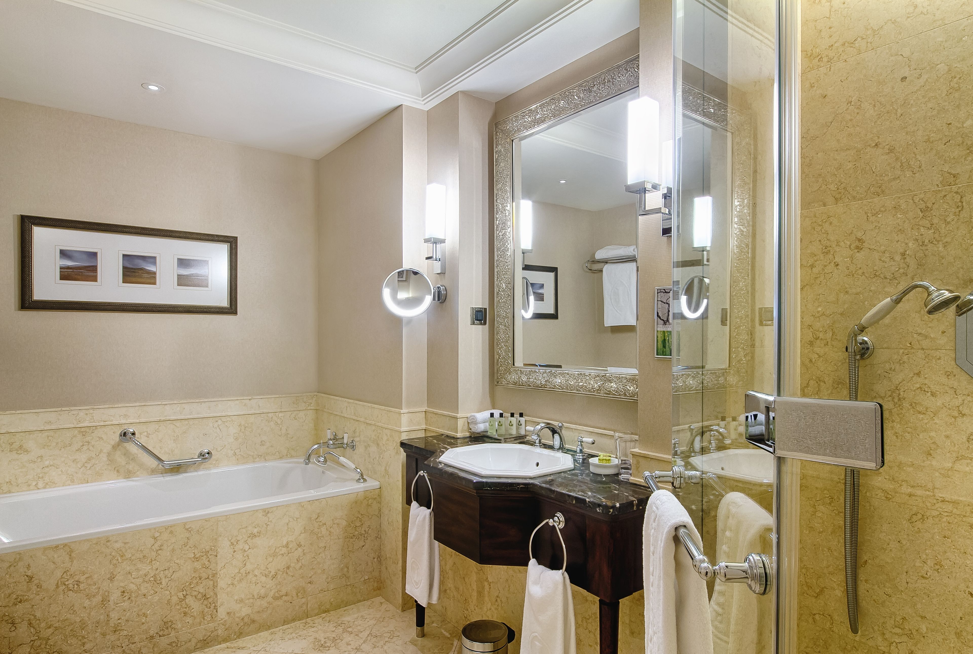 Un baño moderno con bañera, dos lavamanos, un espejo grande y ducha.