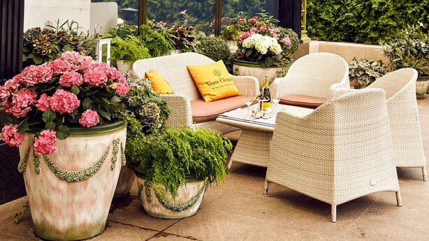 A conservatory with a glass ceiling, wicker furniture, and potted plants. - InterContinental Kyiv by IHG (Kyiv)