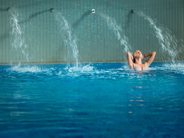 A swimming pool with multiple water jets spraying water. - InterContinental Kyiv by IHG (Kyiv)