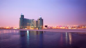 A modern hotel with a glass facade, situated by a waterfront. - InterContinental Residence Suites Dubai Festival City by IHG (Dubai)