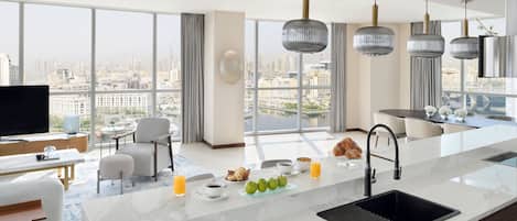 Una cocina moderna con una isla grande, un comedor y vistas a la ciudad.