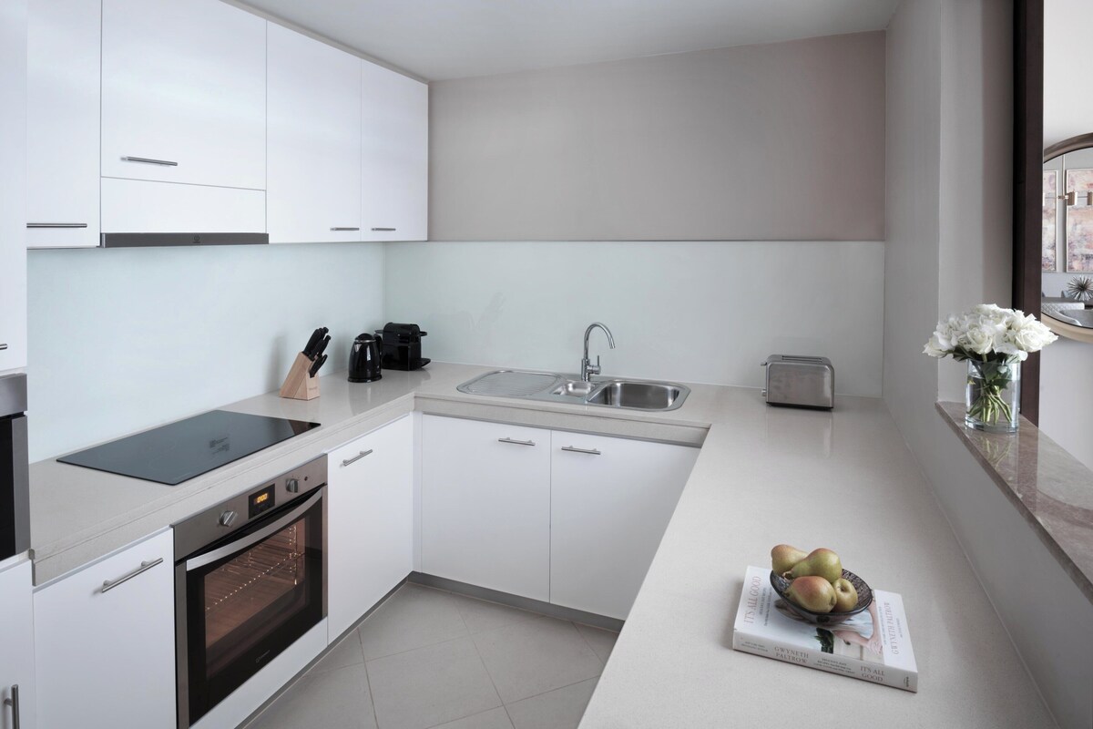 Eine moderne Küche mit weißen Schränken, einem Backofen, einer Spüle und einem Toaster.
