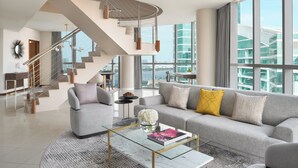 A modern living room with a grey sofa, a glass coffee table, and a staircase leading to an upper floor. - InterContinental Residence Suites Dubai Festival City by IHG (Dubai)