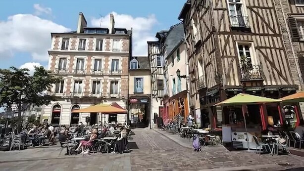 A cobblestone street with traditional European architecture, outdoor seating for cafes, and bicycles parked along the sidewalk. - Appart'City Classic Rennes Beauregard (Rennes)