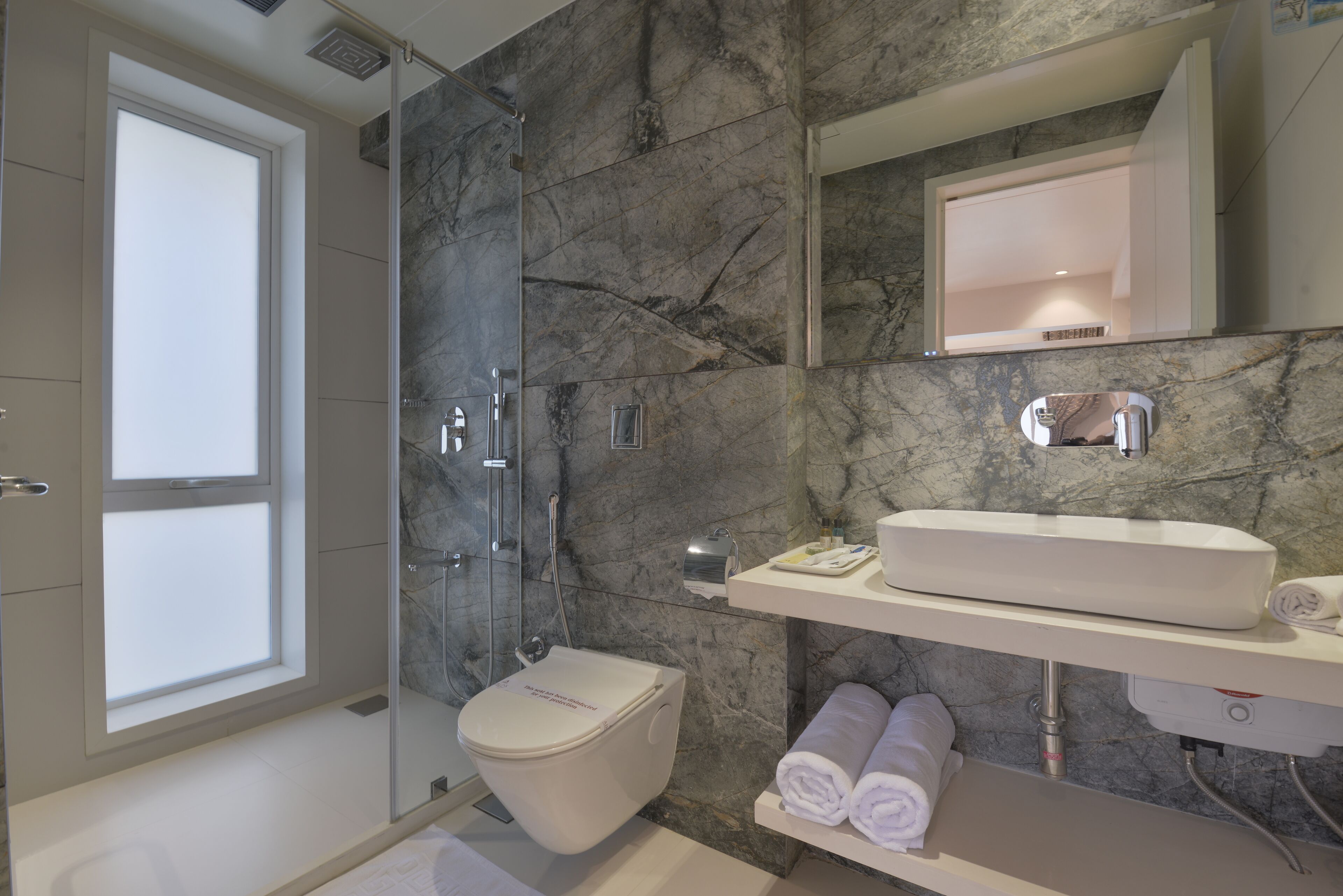 Un baño moderno con inodoro, ducha y lavabo.
