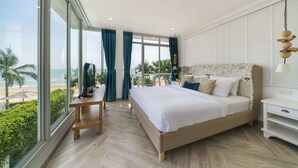 A modern bedroom with a large bed, a desk, and a view of the beach. - Tolani Le Bayburi Villas Pranburi (Pranburi)