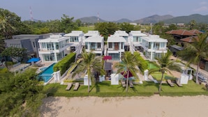 A modern resort with multiple white buildings, a pool, palm trees, and a beach. - Tolani Le Bayburi Villas Pranburi (Pranburi)