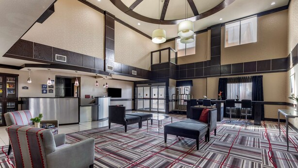 Een ruime lobby met een modern ontwerp, met een bekleed vloerkleed, comfortabele zitplaatsen en een centraal gelegen gedeelte met een balie en zithoek.