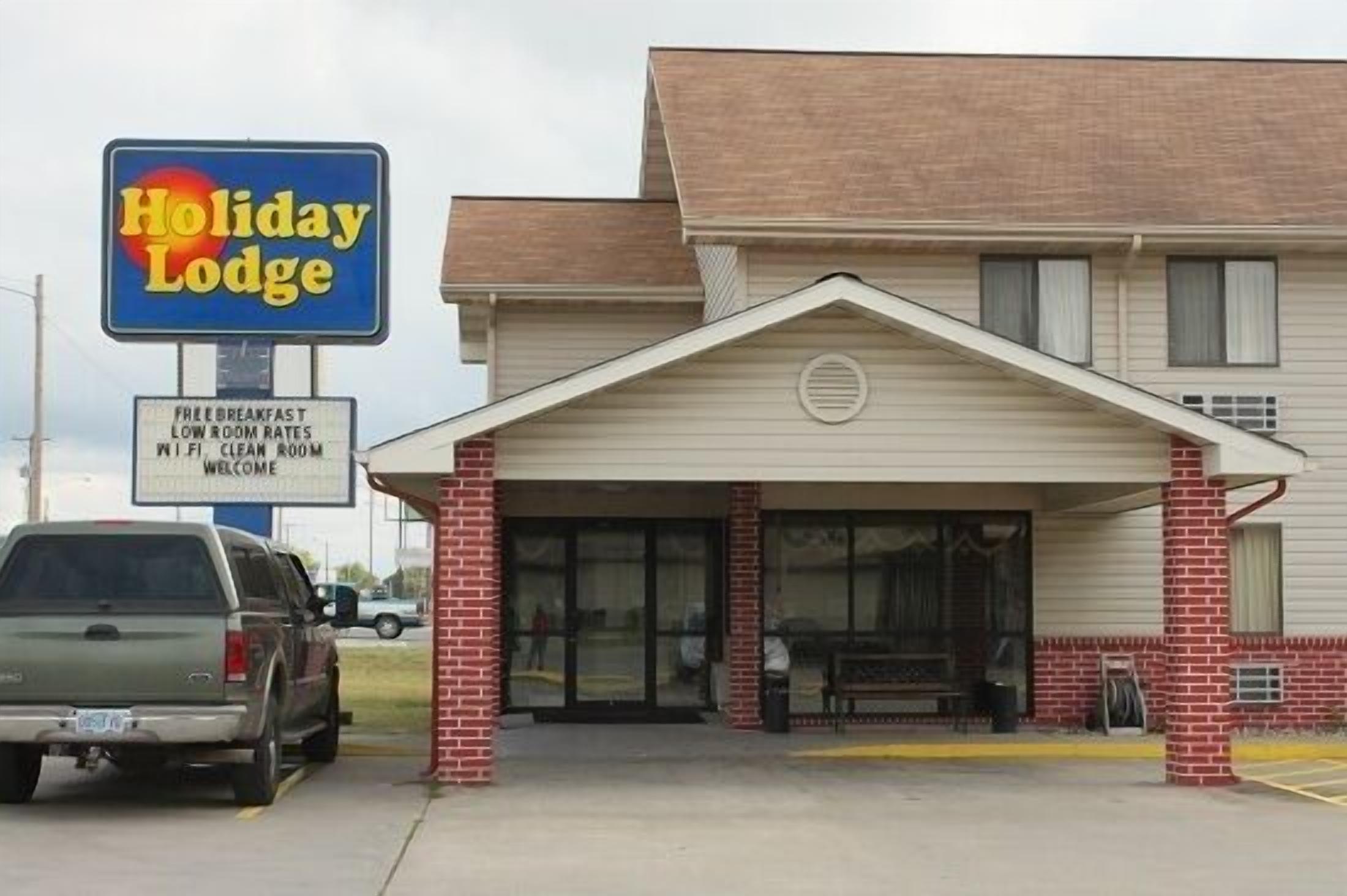 A Holiday Lodge with a clear signboard, a covered entrance, and a brick facade.