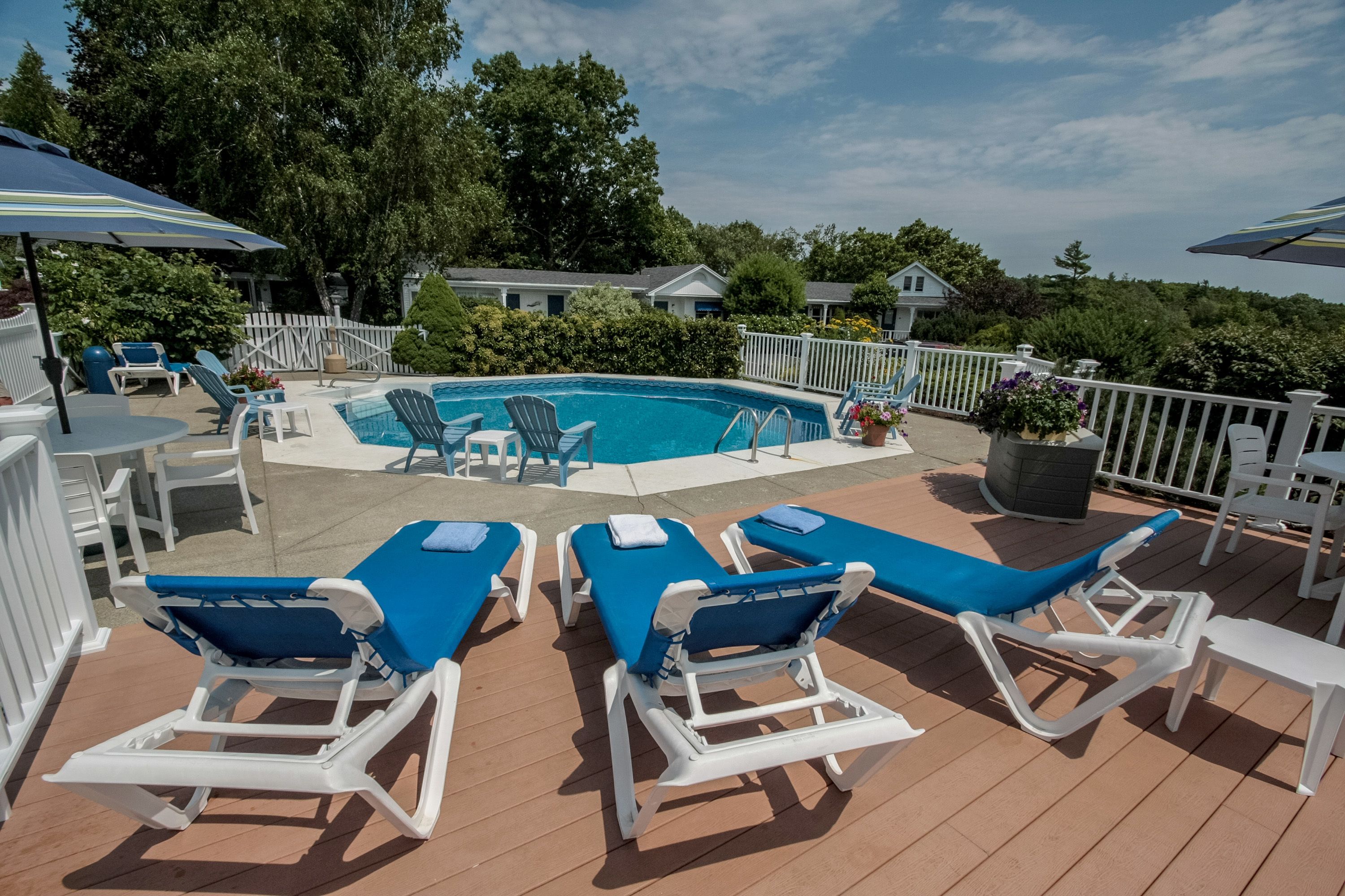 A pool area with lounge chairs and umbrellas.