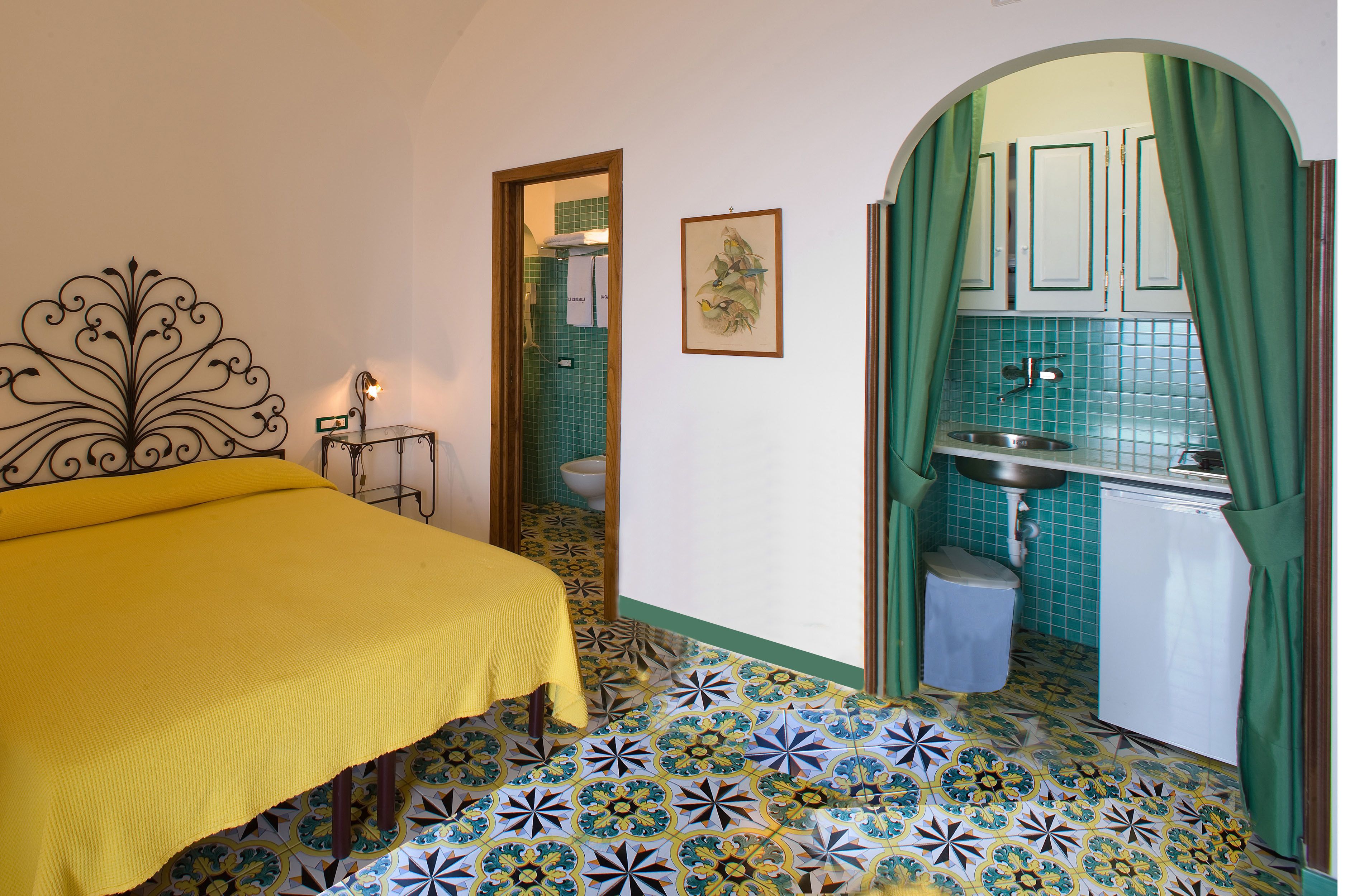 A bedroom with a bed, a small table, and a bathroom visible through an open door.