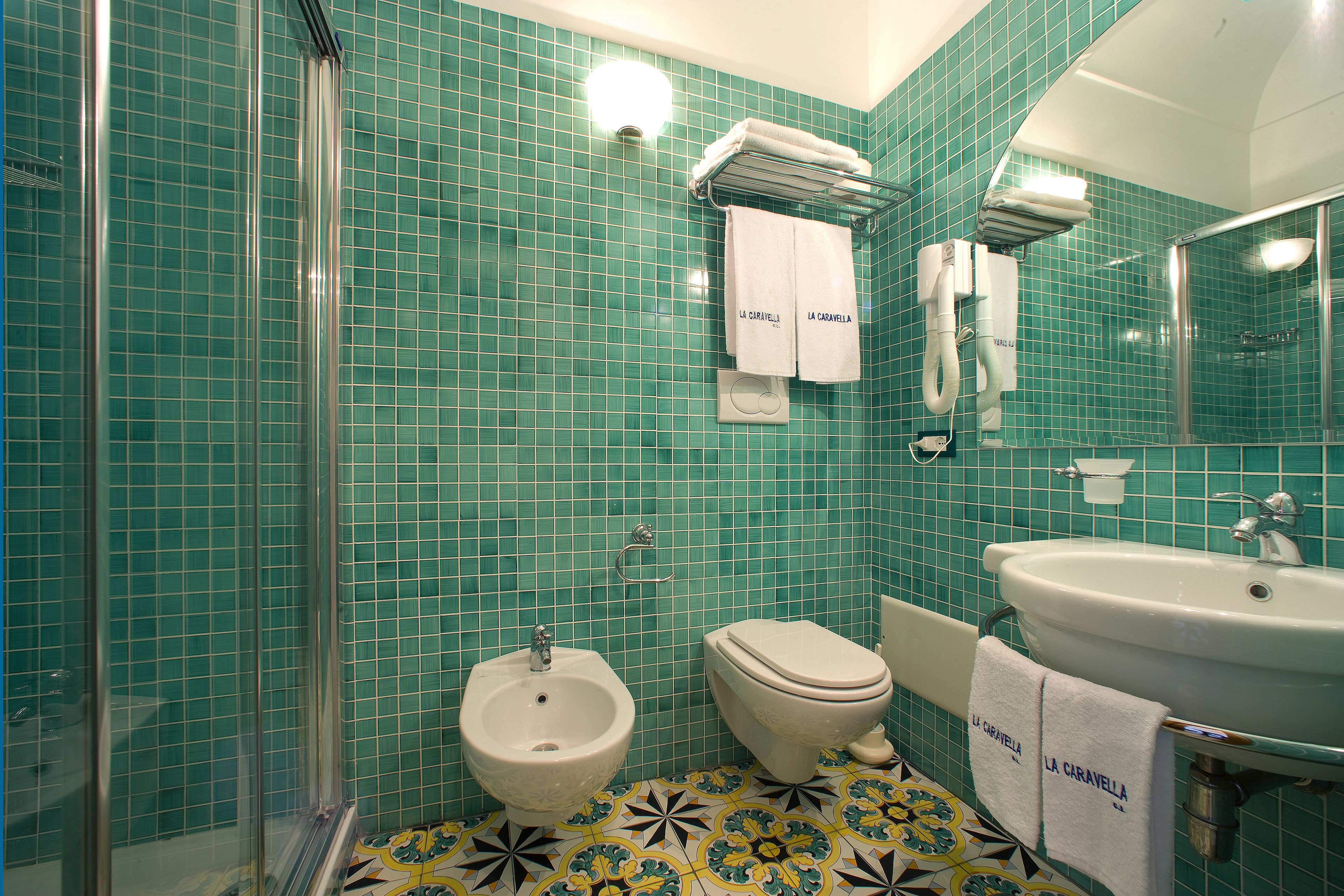 Ein Badezimmer mit Bidet, Toilette, Waschbecken und Duschbereich.