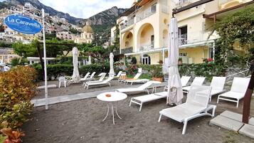 Un resort con asientos al aire libre, un letrero de La Caravella y vistas a las montañas.