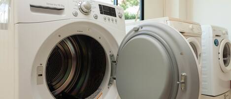 A front-loading LG washer and dryer in a laundry room with a window view.