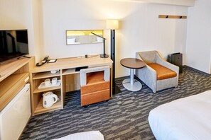 A hotel room with a bed, a desk with a lamp, a chair, a small table, and a television. - Smile Hotel Tokyo Asagaya (Tokyo)