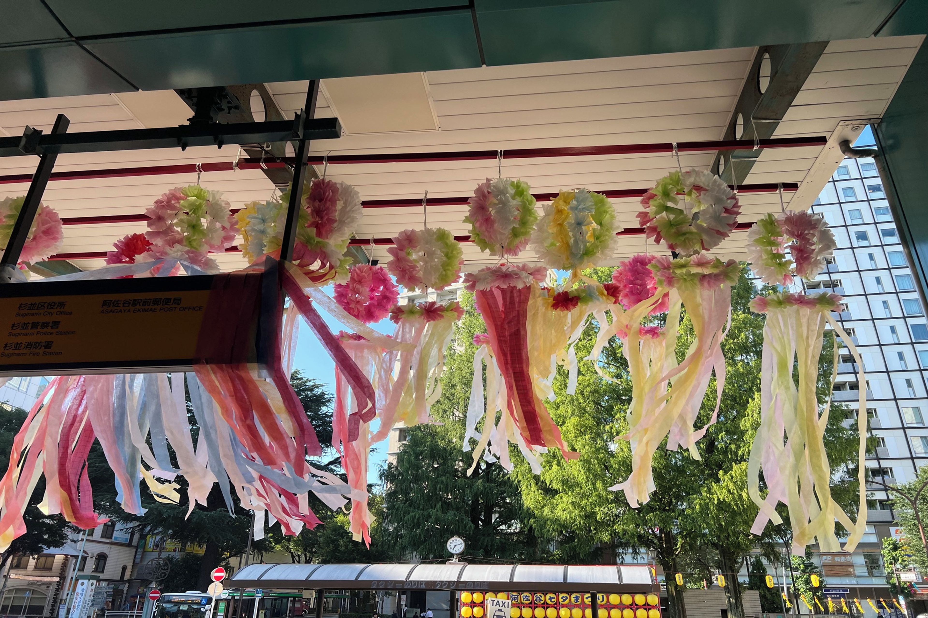 En byggnad med en överbyggd entré som är dekorerad med upphängda pappersblommor och band.
