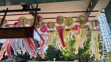 A building with a covered entrance area decorated with hanging paper flowers and ribbons.