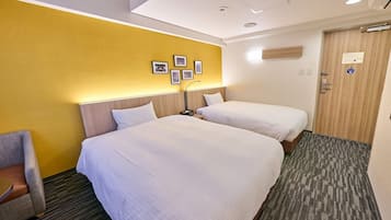 A hotel room with two beds, a chair, and a door with a sign.