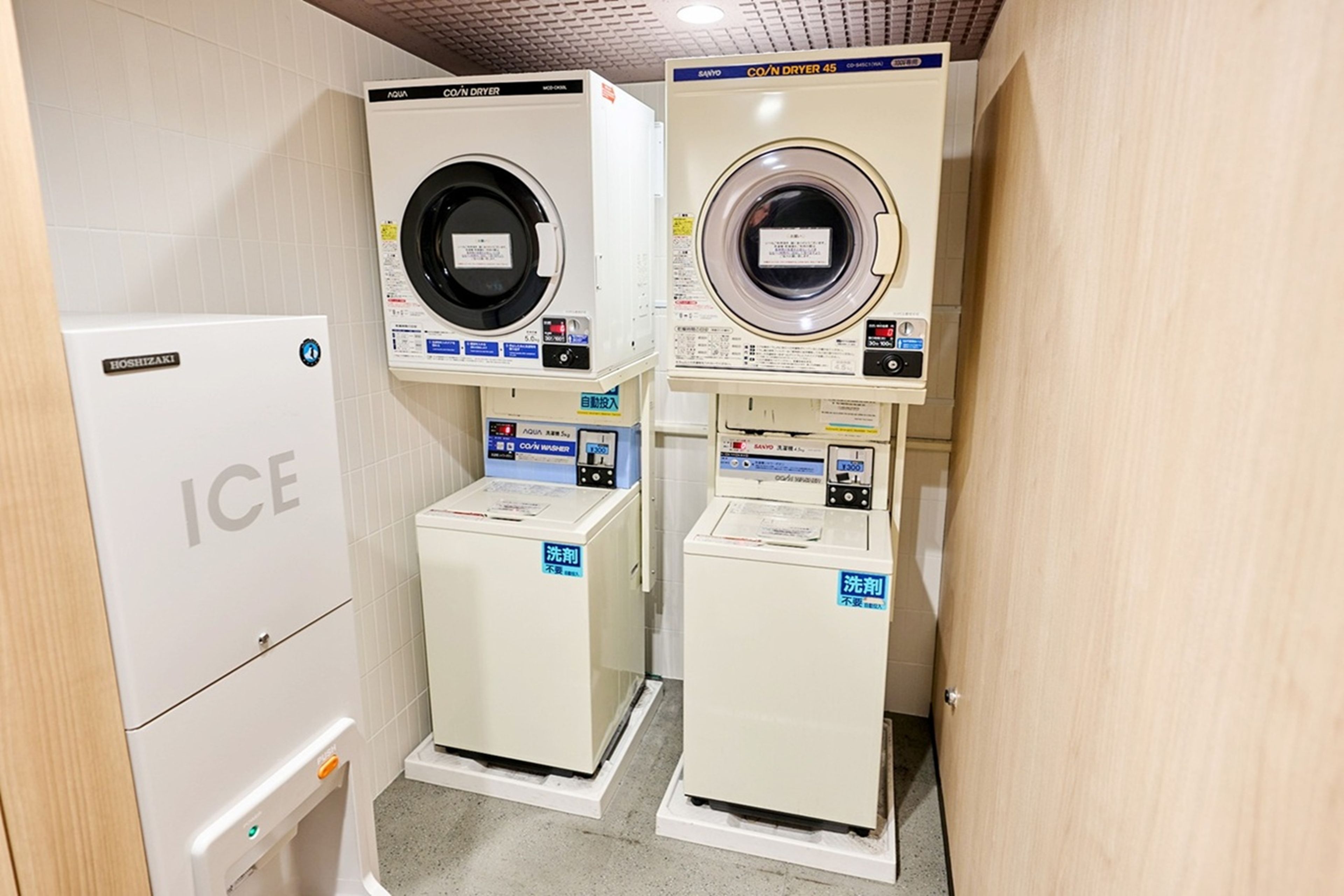 A laundry facility with two washing machines and a refrigerator.