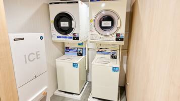 A laundry facility with two washing machines and a refrigerator.