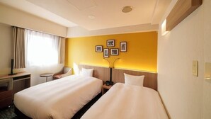 A hotel room with two beds, a desk, and a chair. There are framed pictures on the wall and a window with curtains. - Smile Hotel Tokyo Asagaya (Tokyo)