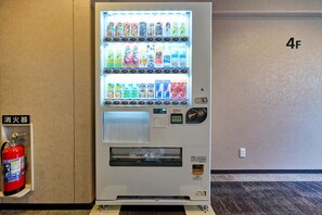 A vending machine with various beverages and snacks, a fire extinguisher, and a wall number '4F'. - Smile Hotel Tokyo Asagaya (Tokyo)