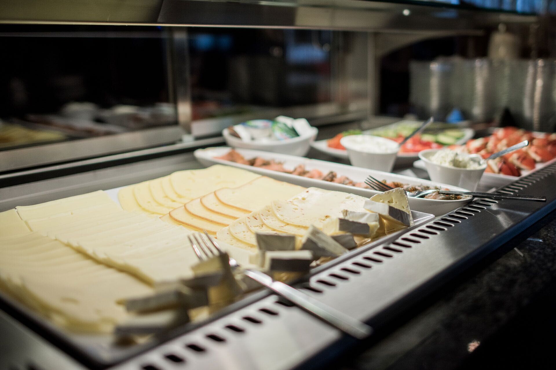 A buffet with various food items and utensils.