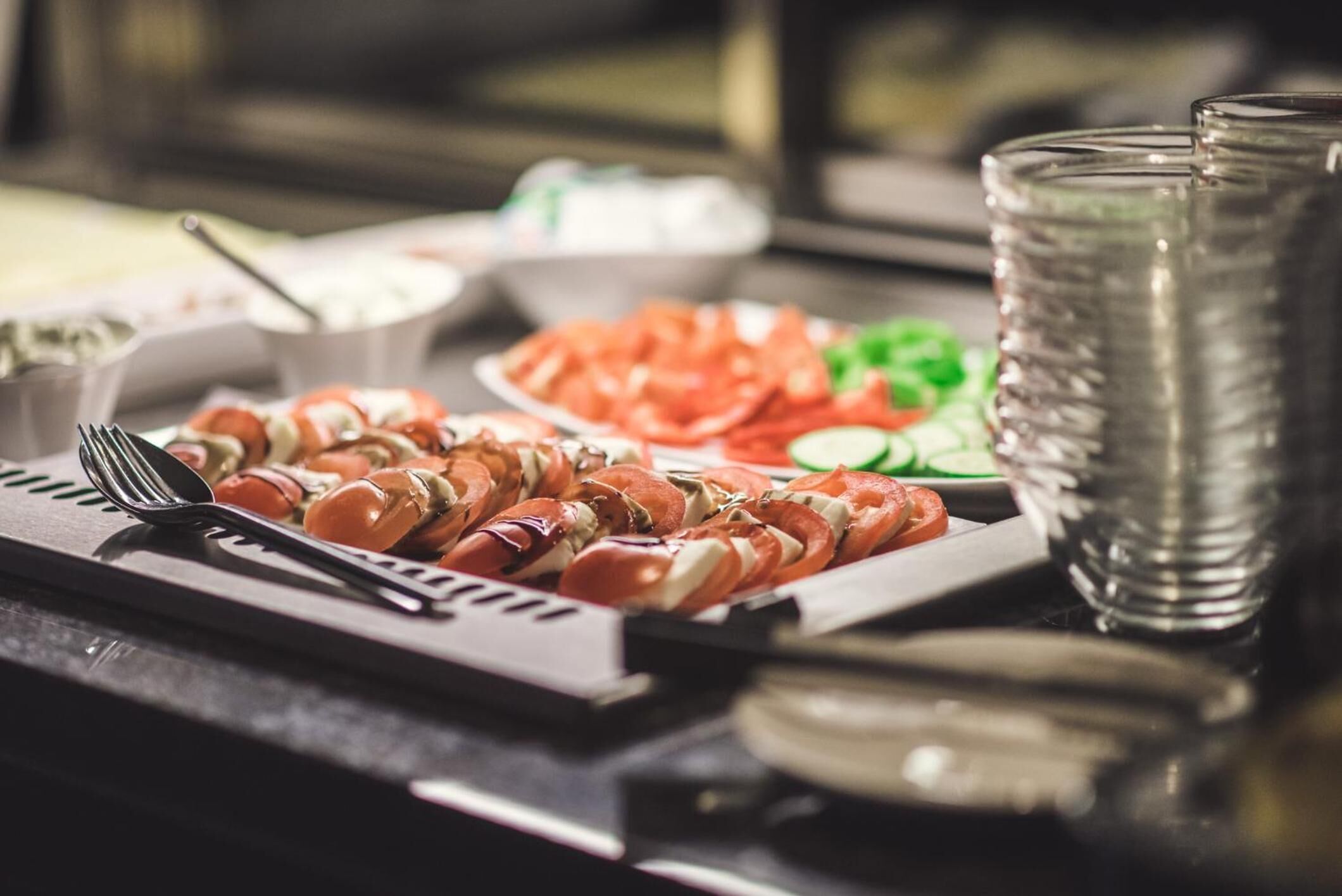 Una mesa de buffet con diversos alimentos y utensilios.