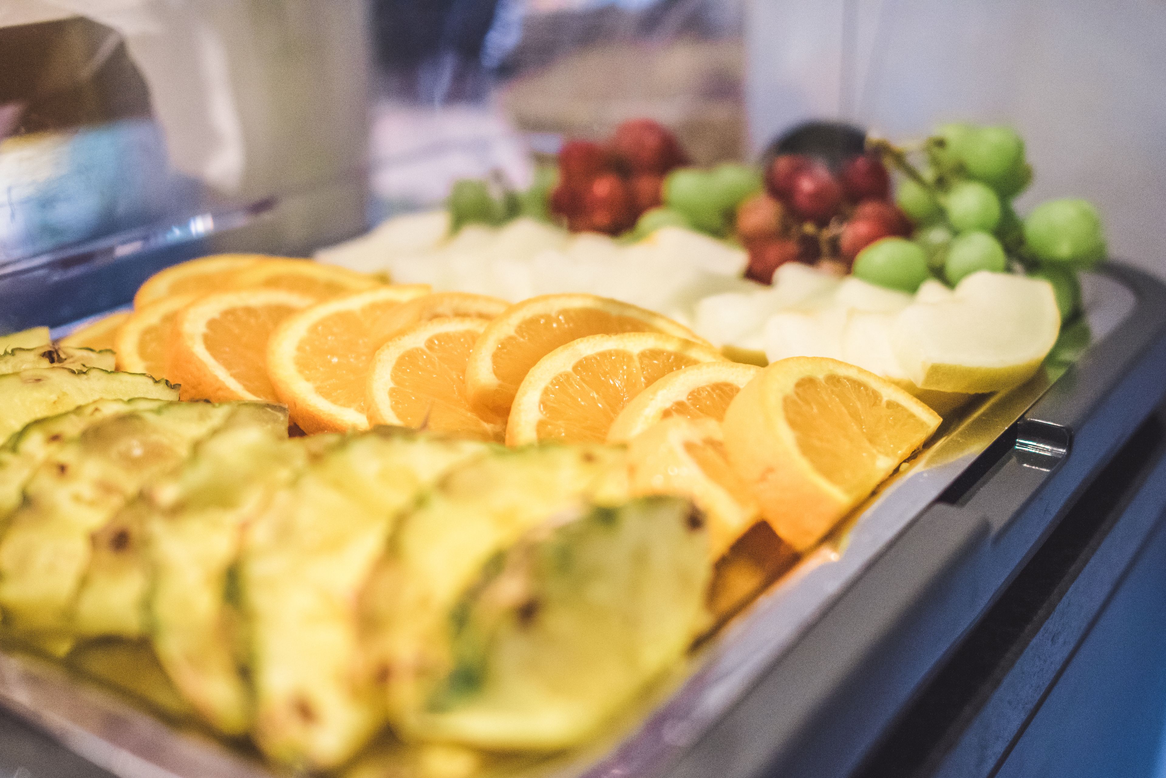 Eine Obstplatte mit Orangenscheiben, Äpfeln und Trauben.