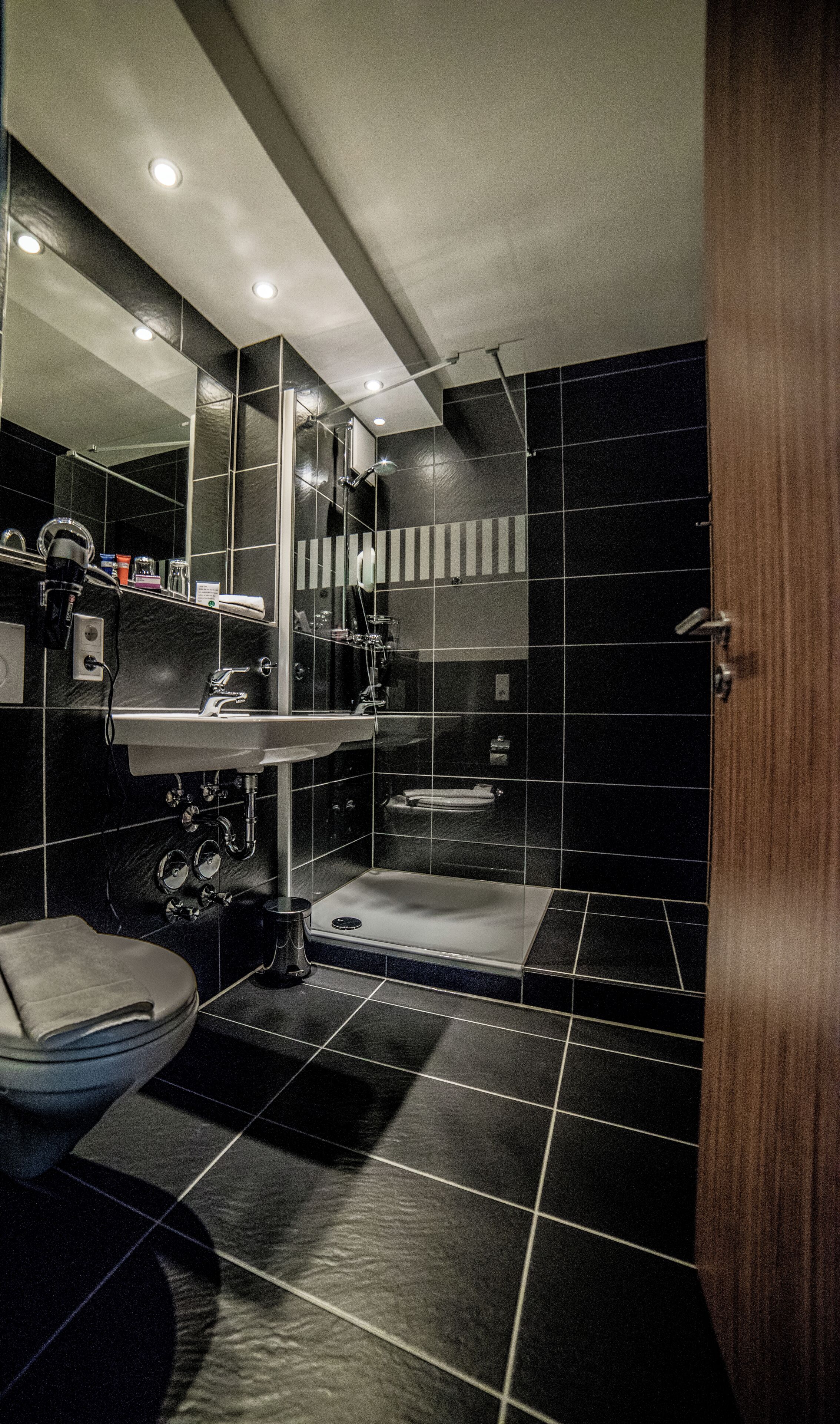 Ein modernes Badezimmer mit Waschbecken, Toilette und Duschbereich.