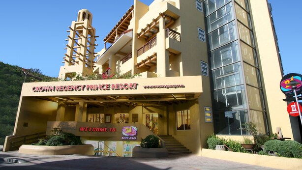 Un hotel de diseño moderno, con una entrada destacada que muestra el letrero "Crown Regency Prince Resort".