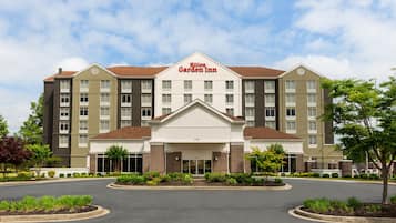 Un hôtel Hilton Garden Inn doté d’une entrée centrale, de plusieurs étages et d’une façade en briques.