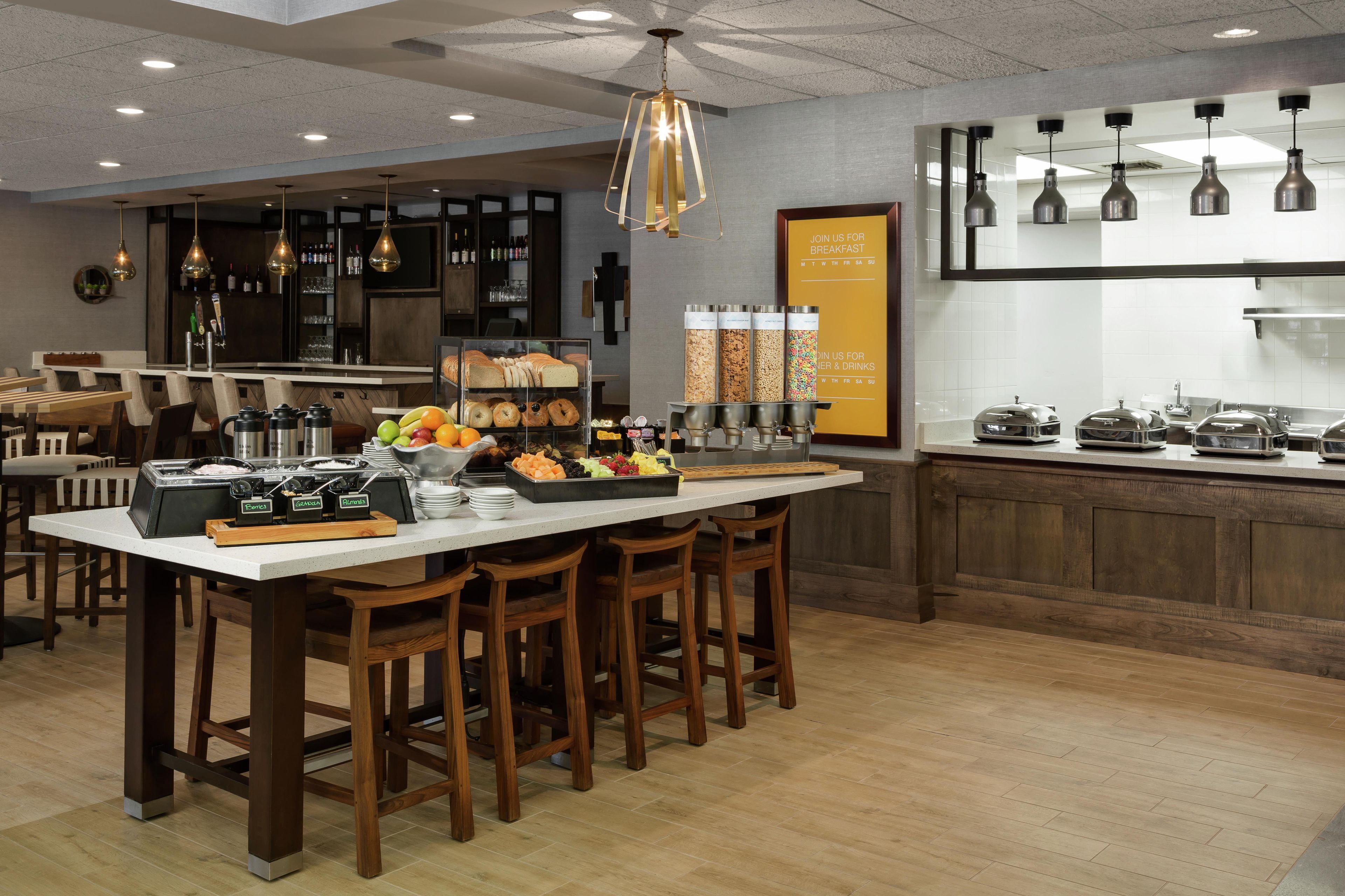 A modern kitchen with a central island, bar area, and breakfast service counter.