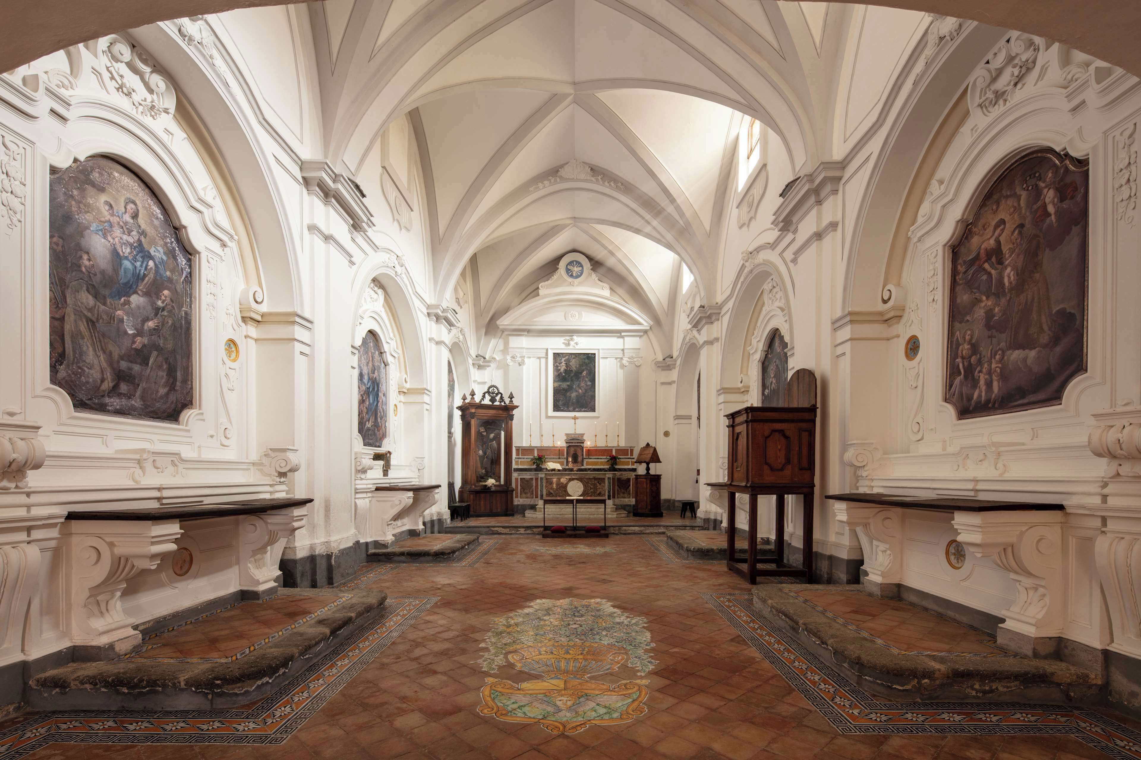 Ein kunstvoll gestalteter Kirchenraum mit hohen Decken, detaillierten Wandmalereien und einem zentralen Altar.