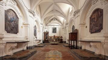 Ein kunstvoll gestalteter Kirchenraum mit hohen Decken, detaillierten Wandmalereien und einem zentralen Altar.