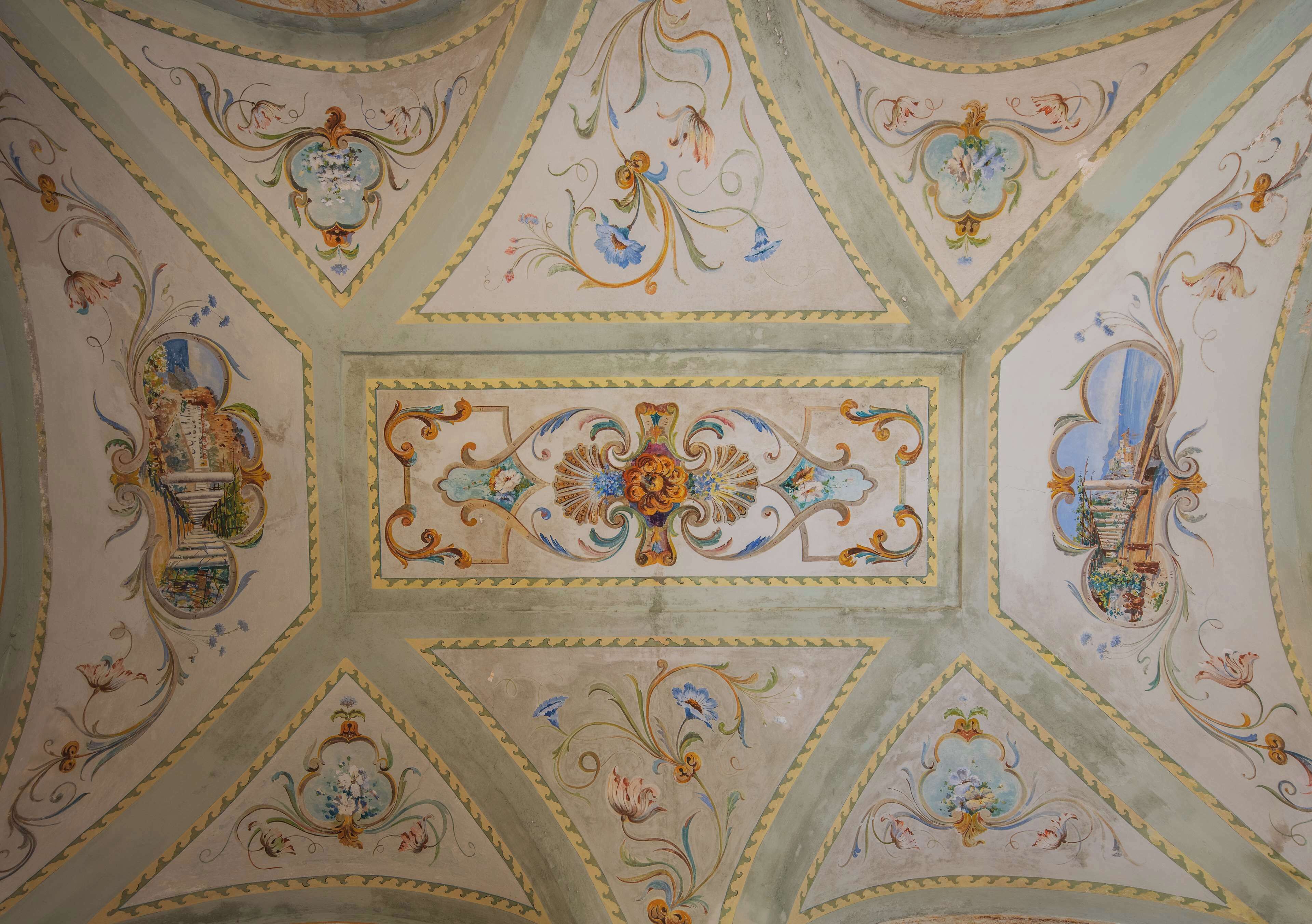 A ceiling with geometric patterns and floral motifs.