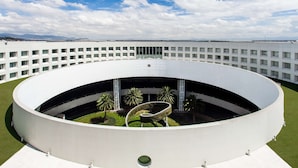 Un edificio moderno con un patio central circular, rodeado por un exterior blanco.