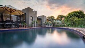 A swimming pool with a patio area, including outdoor furniture and a pergola. - Murray Street 137 Guest House (Pretoria)