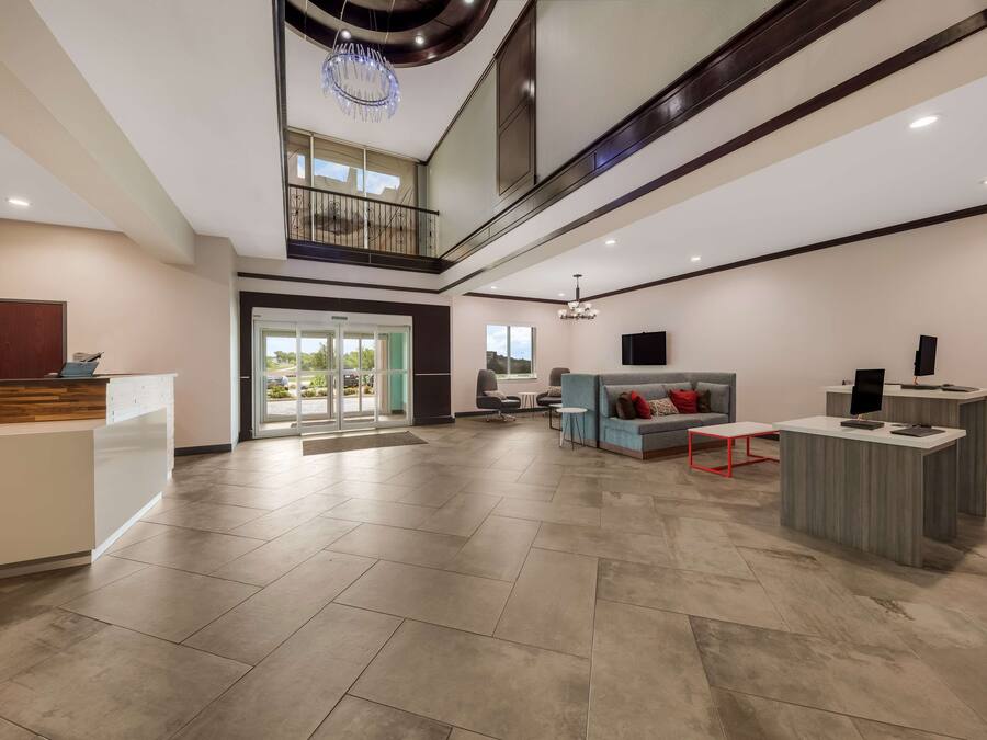 A spacious lobby with a reception desk, seating area, and a balcony.
