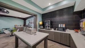 A modern kitchen with a central island, a microwave, and a refrigerator. - Best Western Plus Bowie Inn & Suites (Bowie)