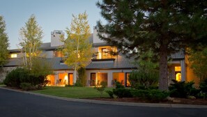 A modern two-story house with a well-maintained lawn and large windows.