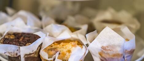 A tray of assorted pastries in paper wrappers.